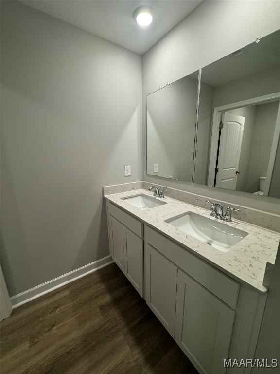 bathroom featuring wood-type flooring, vanity, and toilet