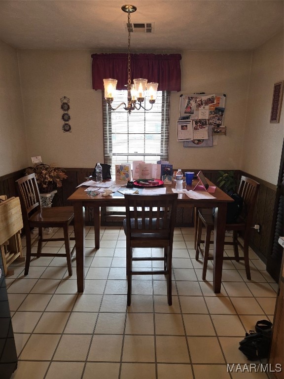 tiled dining room featuring a notable chandelier