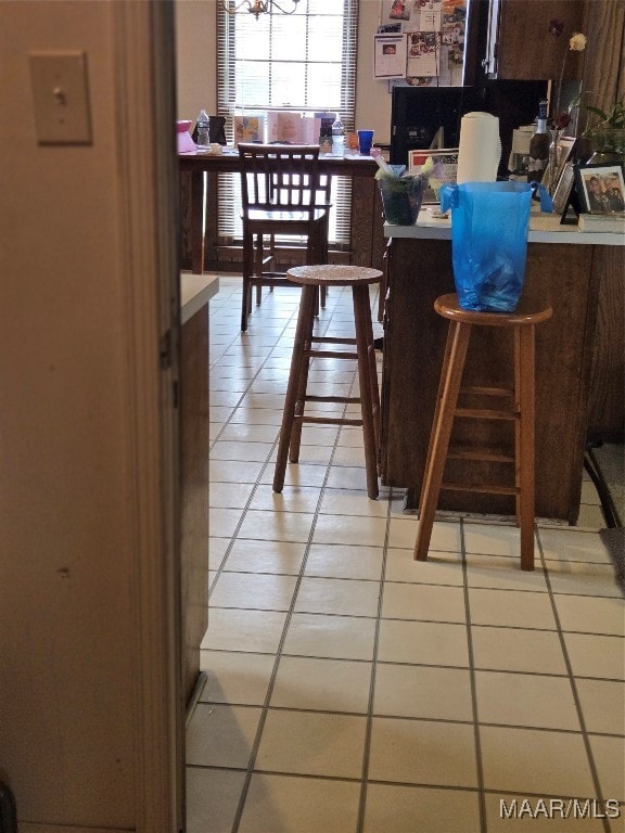 dining area with a chandelier and light tile patterned flooring