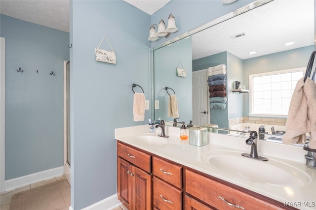 bathroom with vanity, a textured ceiling, tile patterned floors, and plus walk in shower