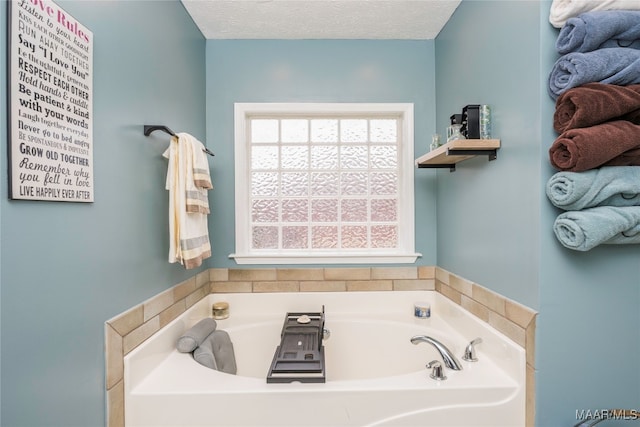 bathroom with a tub and a textured ceiling