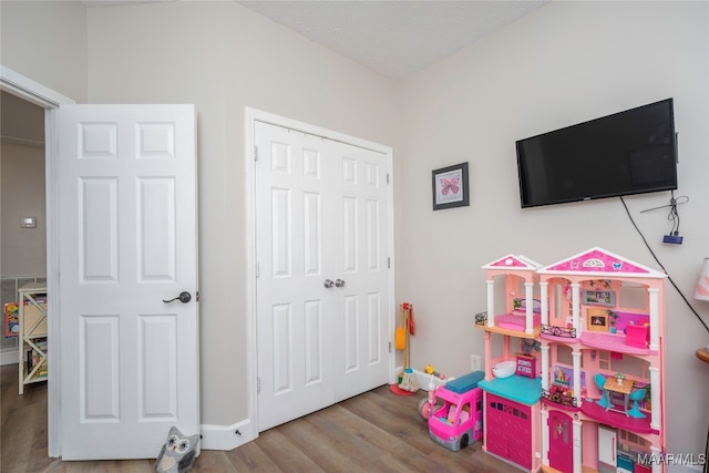 rec room with hardwood / wood-style floors and a textured ceiling