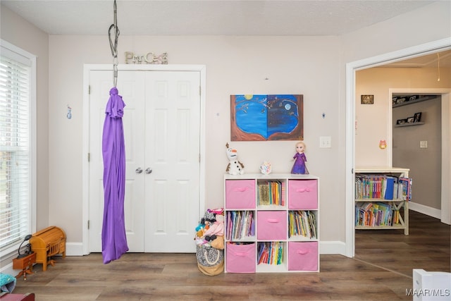 playroom featuring wood-type flooring and a textured ceiling