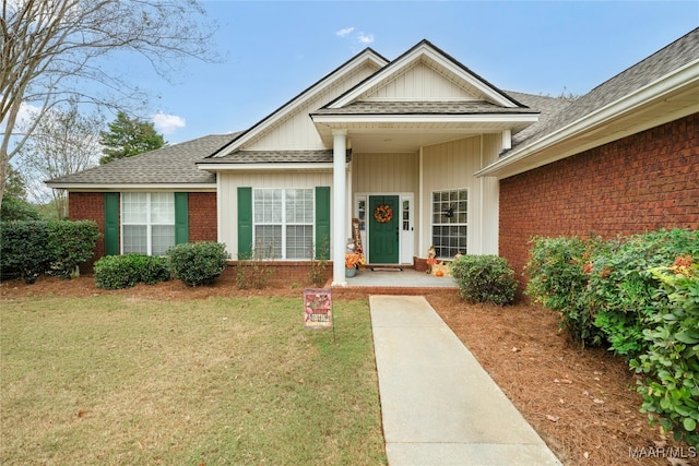 property entrance featuring a lawn and a porch