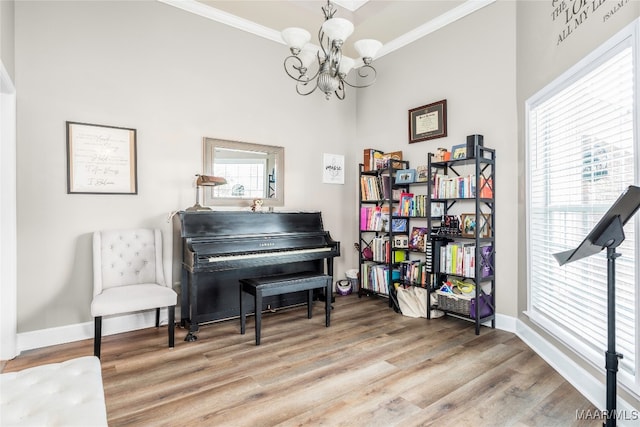 miscellaneous room with a wealth of natural light, wood-type flooring, a chandelier, and ornamental molding