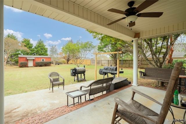 view of patio with a grill, ceiling fan, and a storage shed