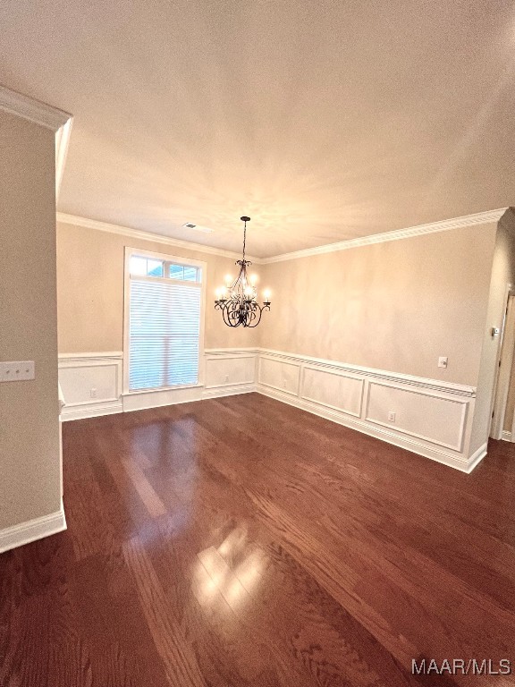 unfurnished room with a textured ceiling, an inviting chandelier, dark hardwood / wood-style flooring, and ornamental molding