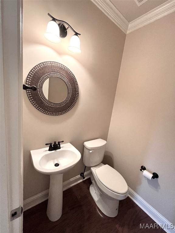 bathroom featuring ornamental molding, hardwood / wood-style floors, and toilet