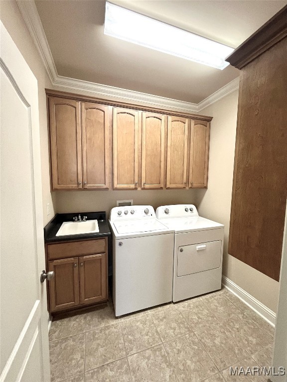 clothes washing area featuring cabinets, separate washer and dryer, sink, and crown molding