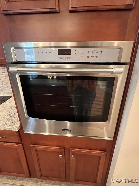 details featuring stainless steel oven and light stone countertops