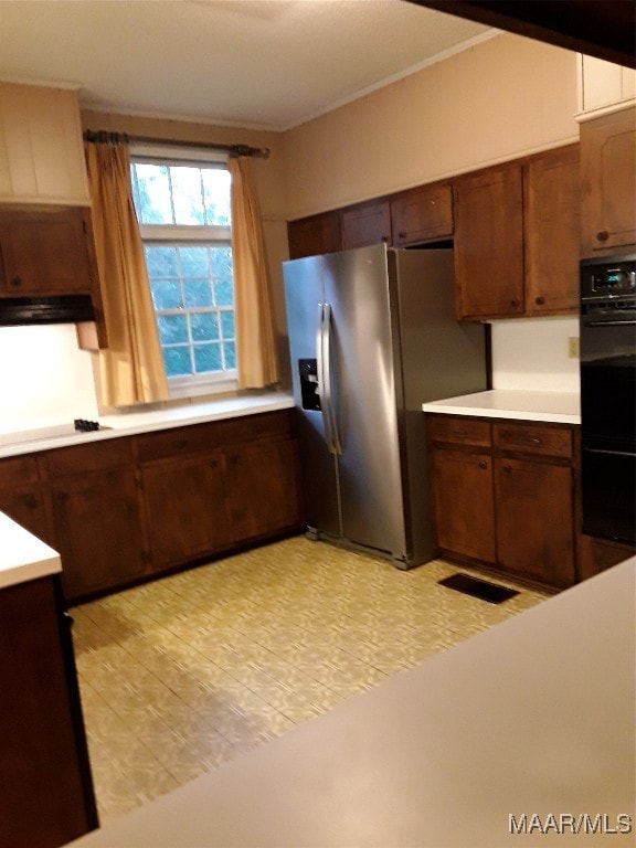 kitchen featuring double oven, stainless steel fridge with ice dispenser, and dark brown cabinets