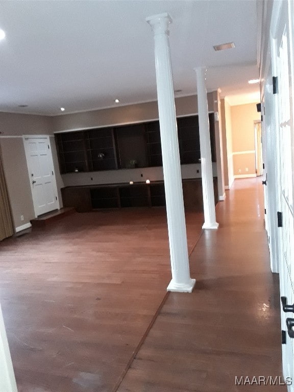 unfurnished living room with dark hardwood / wood-style floors and decorative columns