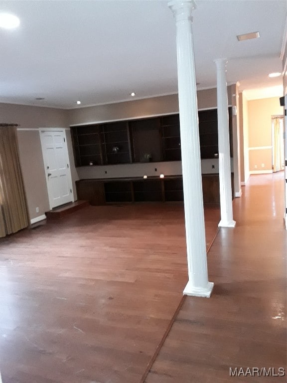 unfurnished living room featuring hardwood / wood-style flooring and ornate columns