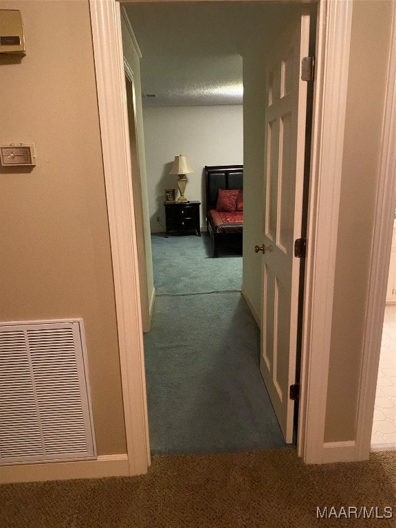 hallway with dark colored carpet