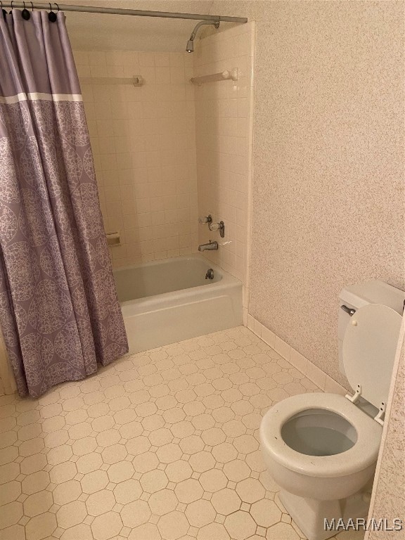 bathroom with toilet and shower / tub combo with curtain