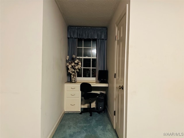 unfurnished office with dark carpet and a textured ceiling