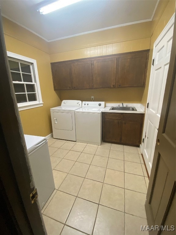 laundry room featuring crown molding, cabinets, separate washer and dryer, and sink