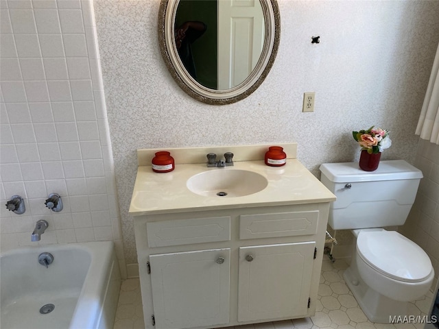 bathroom featuring tile patterned floors, vanity, toilet, and a bathing tub