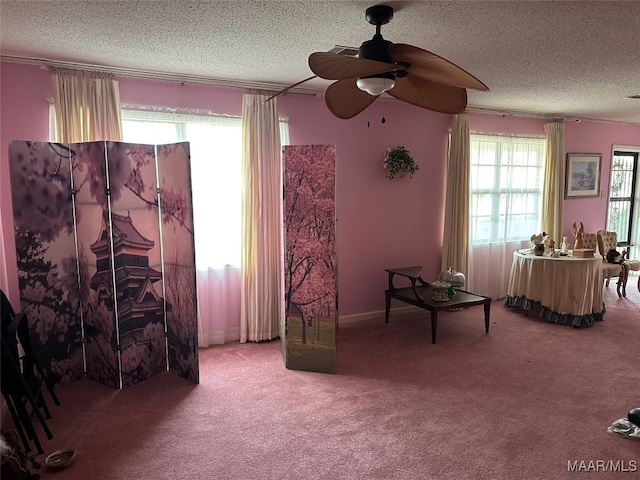 living area with carpet flooring, a textured ceiling, and ceiling fan