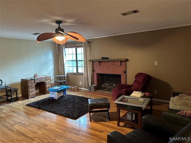 225 Merrimac Dr, Selma, AL 36701 - living room featuring crown molding, a ceiling fan, wood finished floors, a fireplace, and baseboards
