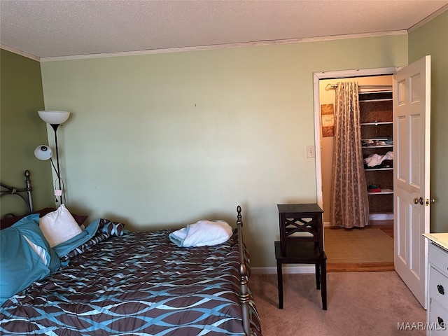 bedroom with a closet, light colored carpet, a textured ceiling, and ornamental molding