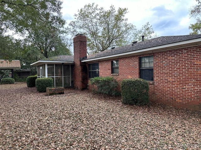 225 Merrimac Dr, Selma, AL 36701 - rear view of house with a sunroom, a chimney, and brick siding