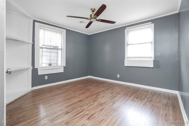 unfurnished room featuring plenty of natural light, light wood-type flooring, and crown molding