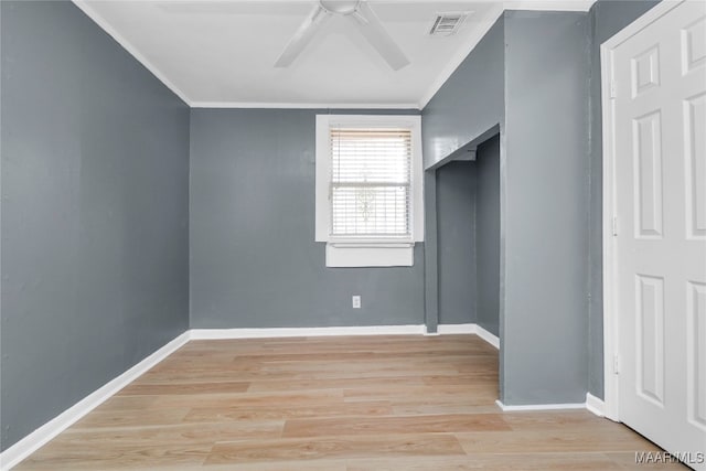 spare room featuring light wood-type flooring, ceiling fan, and crown molding