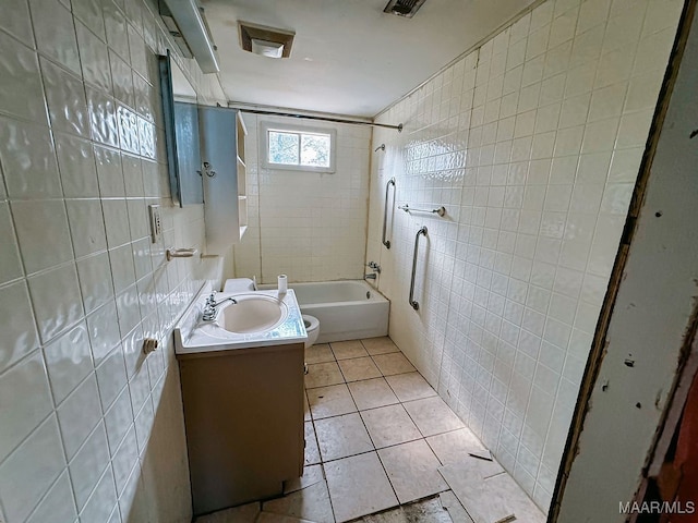 full bathroom with washtub / shower combination, vanity, tile patterned floors, toilet, and tile walls