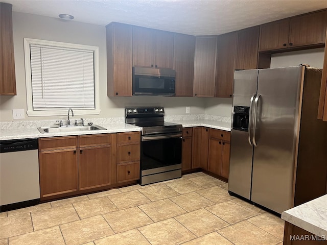 kitchen with a textured ceiling, sink, and appliances with stainless steel finishes