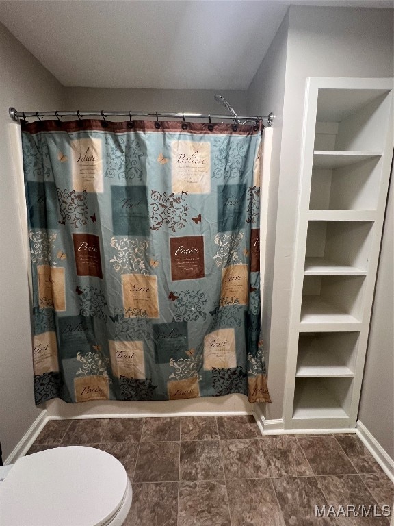 bathroom with a shower with shower curtain and toilet