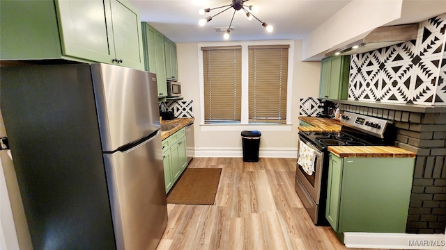 kitchen featuring butcher block counters, light wood-type flooring, green cabinetry, and stainless steel appliances