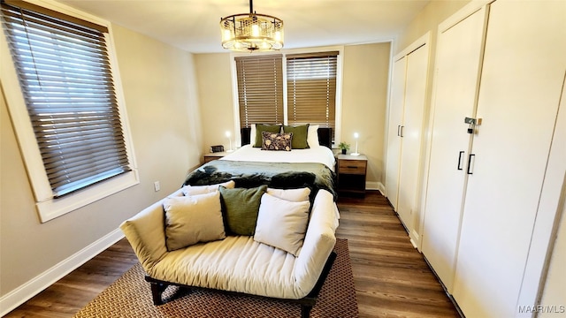 bedroom with dark hardwood / wood-style floors and a notable chandelier