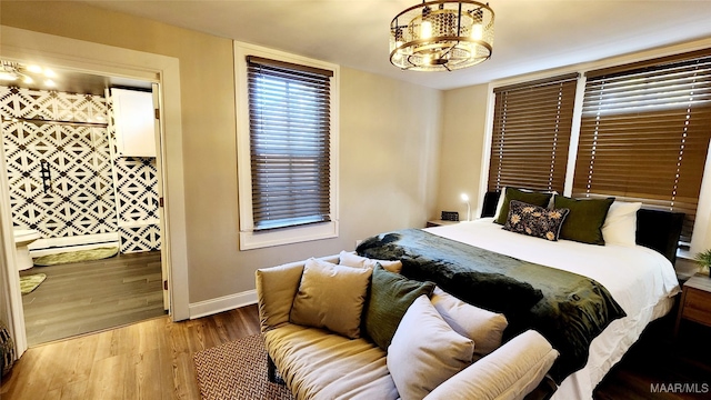 bedroom featuring an inviting chandelier and light hardwood / wood-style flooring