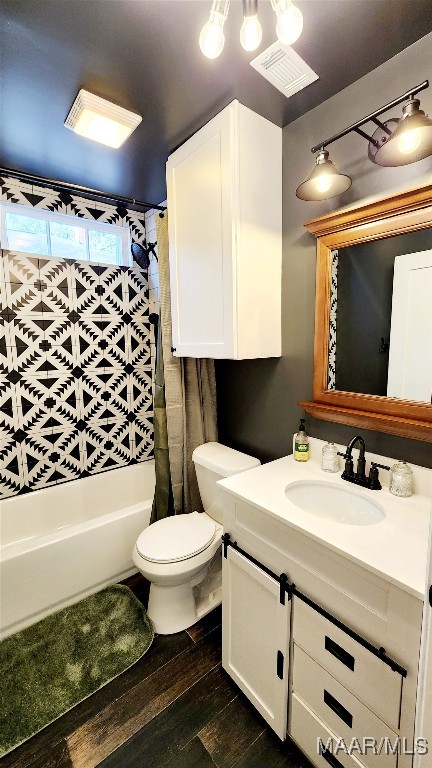 full bathroom featuring shower / bath combo, vanity, hardwood / wood-style flooring, and toilet