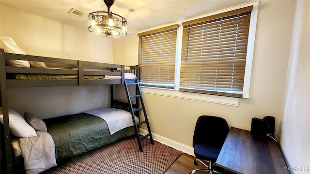 bedroom featuring hardwood / wood-style flooring and a chandelier