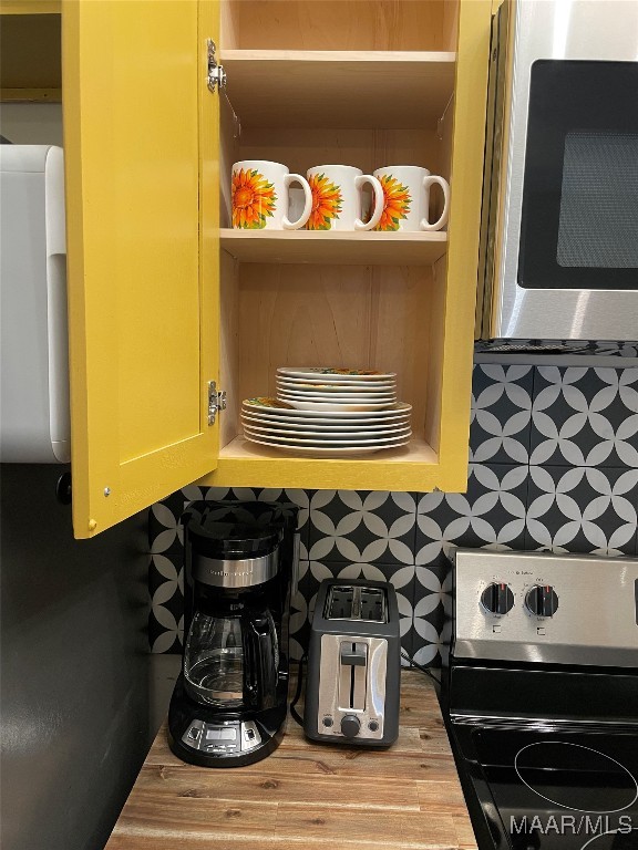 kitchen featuring appliances with stainless steel finishes, decorative backsplash, and hardwood / wood-style flooring