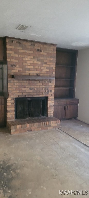 unfurnished living room with a fireplace and concrete floors