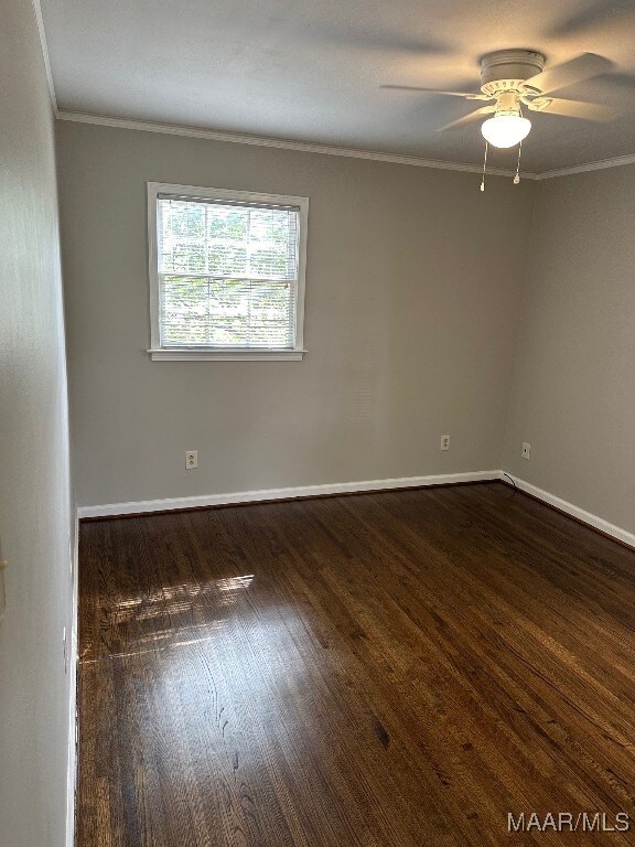 empty room featuring dark hardwood / wood-style flooring, ceiling fan, and crown molding