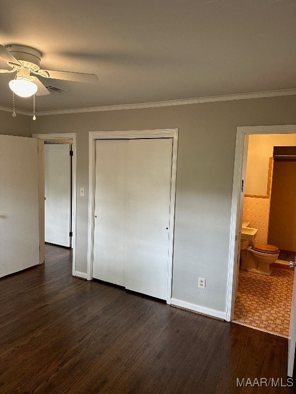 unfurnished bedroom featuring ceiling fan, dark hardwood / wood-style floors, connected bathroom, and crown molding