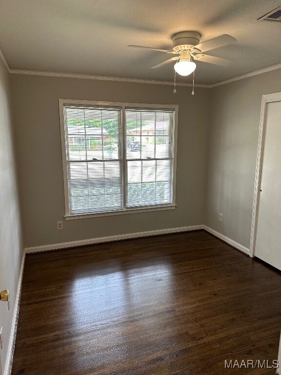 empty room featuring ceiling fan, dark hardwood / wood-style floors, and crown molding