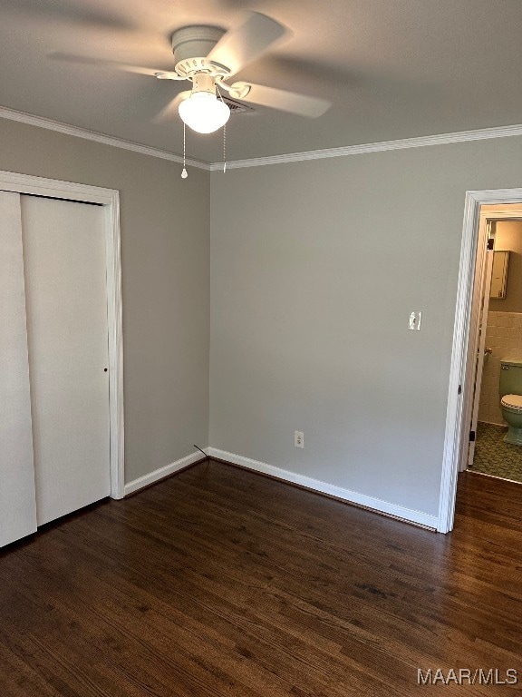 unfurnished bedroom with ornamental molding, ceiling fan, dark hardwood / wood-style floors, connected bathroom, and a closet