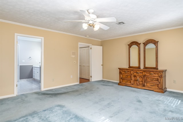 unfurnished bedroom featuring crown molding, light colored carpet, ceiling fan, and ensuite bath