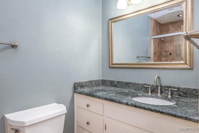 bathroom featuring vanity, toilet, and a shower with shower door