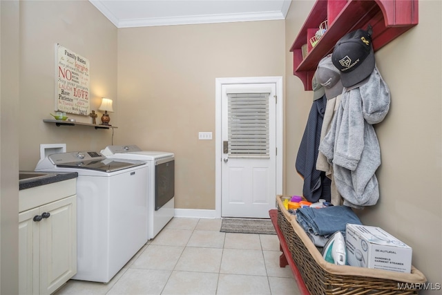 washroom with cabinets, light tile patterned floors, washer and dryer, and ornamental molding