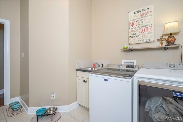 laundry area featuring independent washer and dryer, cabinets, light tile patterned floors, and sink