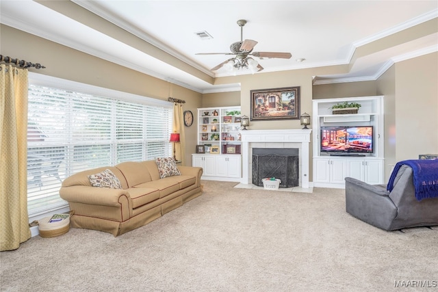 carpeted living room with crown molding and ceiling fan