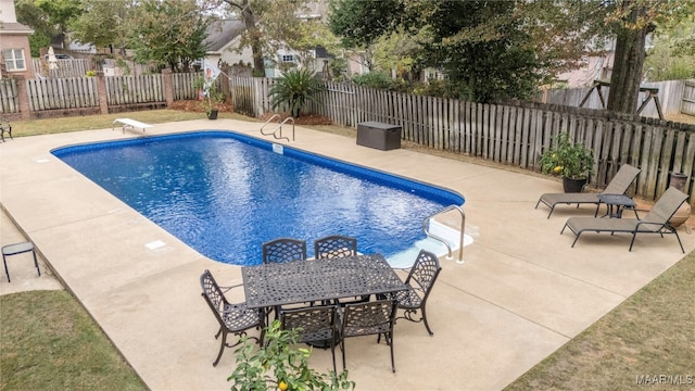 view of swimming pool featuring a patio and a diving board