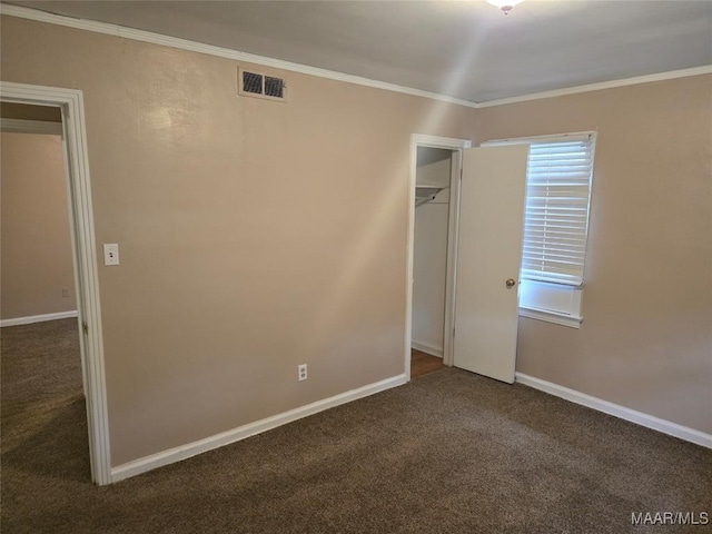 unfurnished bedroom featuring crown molding and dark colored carpet