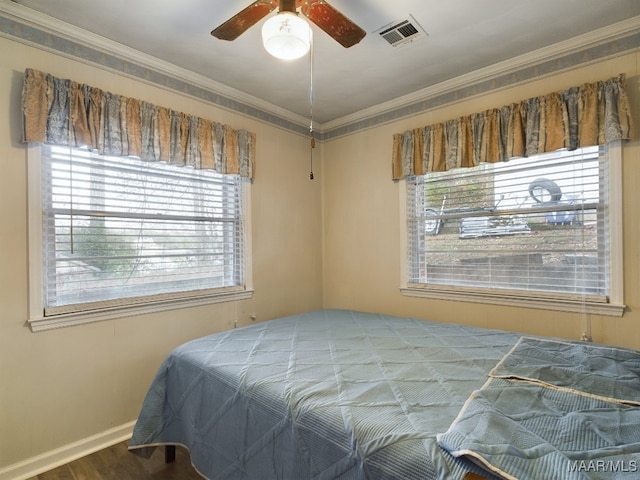 bedroom featuring hardwood / wood-style flooring, multiple windows, ornamental molding, and ceiling fan